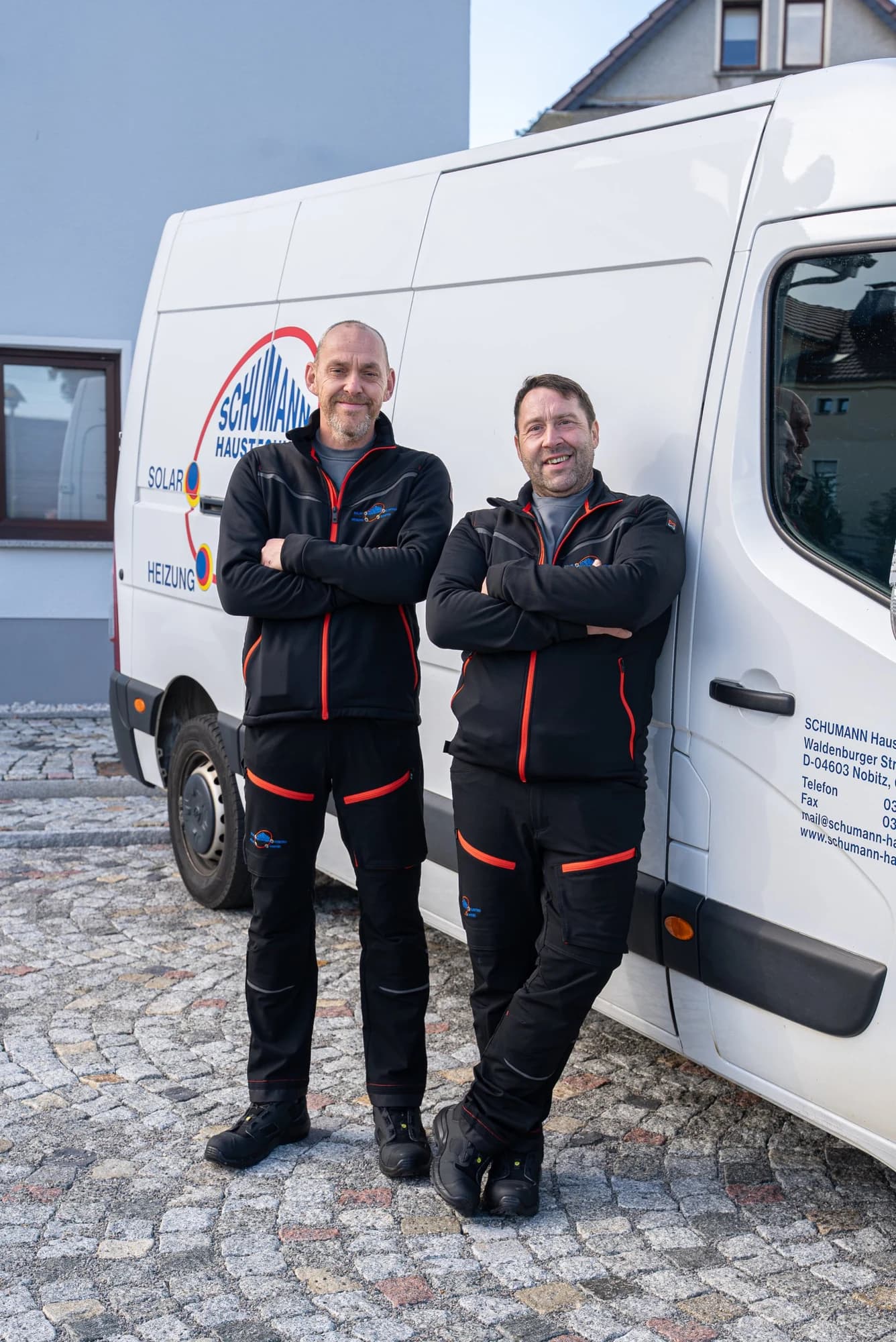 Zwei Monteure von Schumann Haustechnik am Firmenwagen